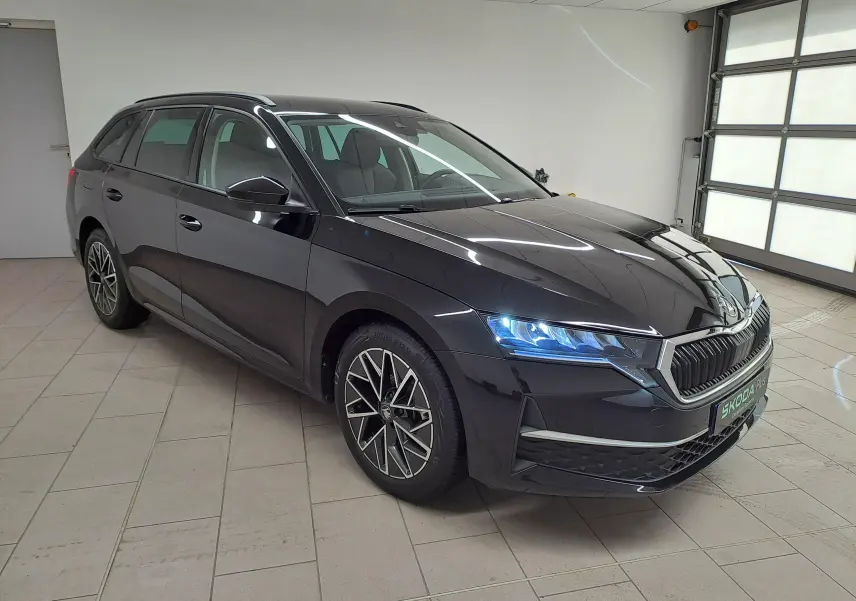 Skoda Octavia Combi 2025 noir Magic nacré vue 3/4 avant droit avec jantes alliage 17'' et phares LED allumés.
