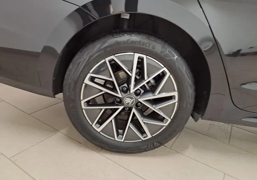 Gros plan sur la roue arrière droite du Skoda Octavia Combi noir Magic nacré avec jante alliage 17'' Slagard Aero polie.