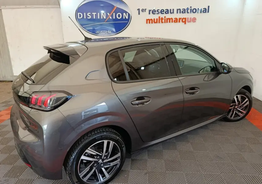 Peugeot 208 BlueHDi 100 S&S Allure Business gris métallisé vue 3/4 arrière droit en intérieur showroom.