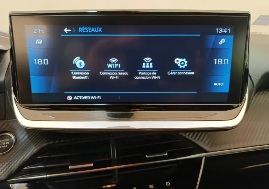 Écran tactile central affichant les options Wi-Fi et Bluetooth dans l’habitacle noir du Peugeot 208 2020.
