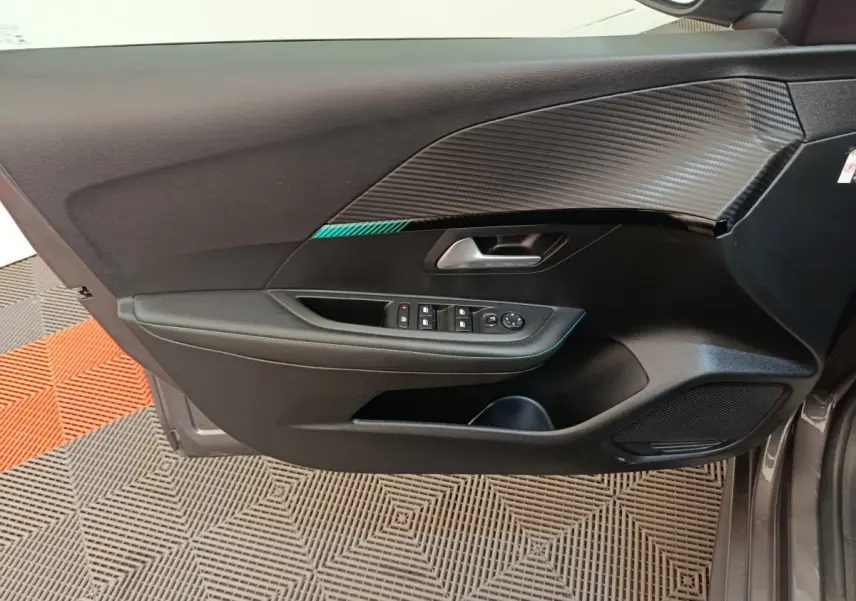 Vue latérale du panneau de porte avant gauche de Peugeot 208 2020 avec garniture noire et insert effet carbone.