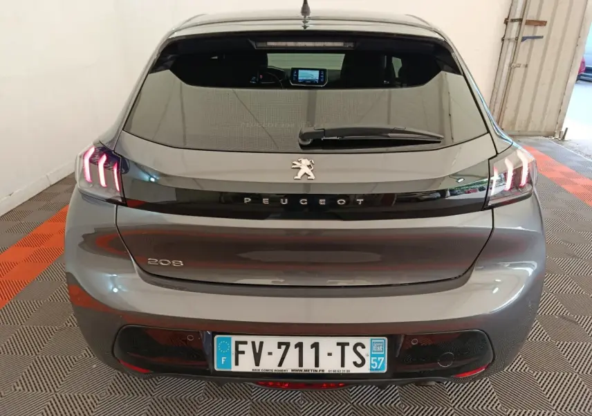 Vue arrière d’une Peugeot 208 gris foncé avec feux LED caractéristiques et plaque d’immatriculation française visible.