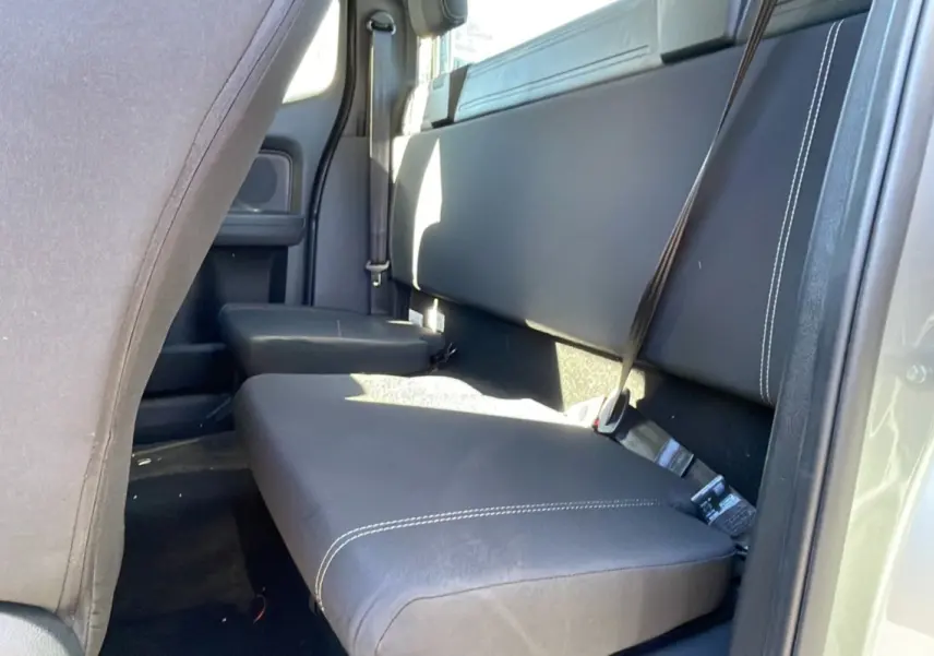 Vue intérieure arrière côté droit du Ford Ranger gris iconic, montrant la banquette en cuir noir avec surpiqûres blanches et ceintures de sécurité.