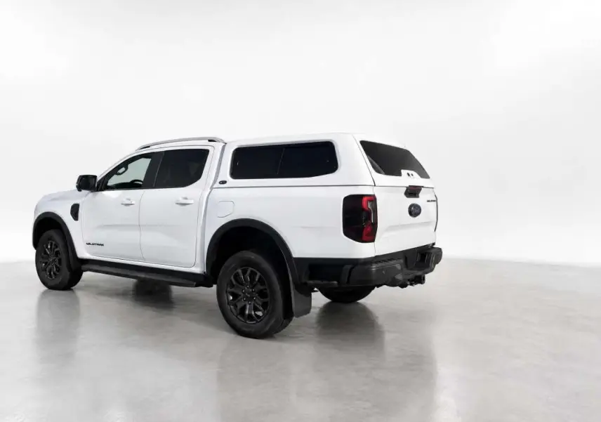 Ford Ranger Wildtrak blanc glacier vu en 3/4 arrière droit avec hardtop vitré et jantes noires.