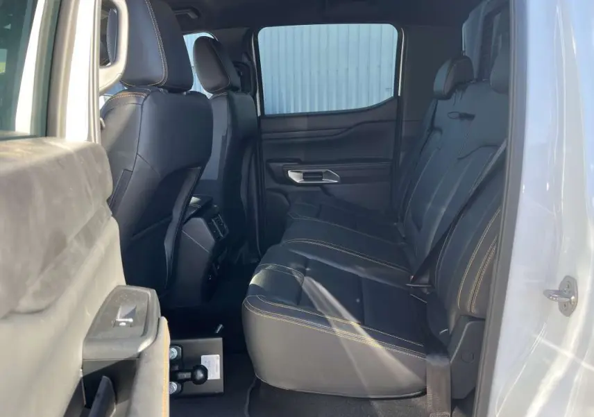 Vue latérale droite de l’intérieur arrière du Ford Ranger blanc glacier, sièges en cuir noir avec surpiqûres contrastantes.