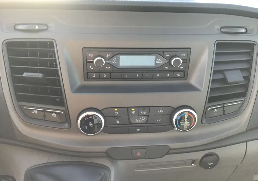 Tableau de bord du Ford Transit Chassis Cabine blanc, vue frontale centrée sur la console audio et climatisation.