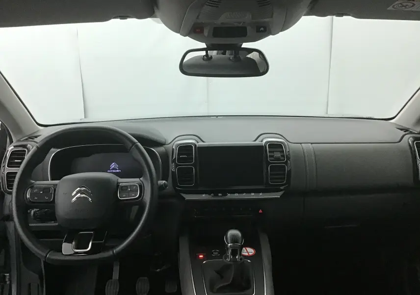 Vue frontale de l'habitacle noir du Citroën C5 Aircross gris, avec tableau de bord moderne et écran tactile central éteint.