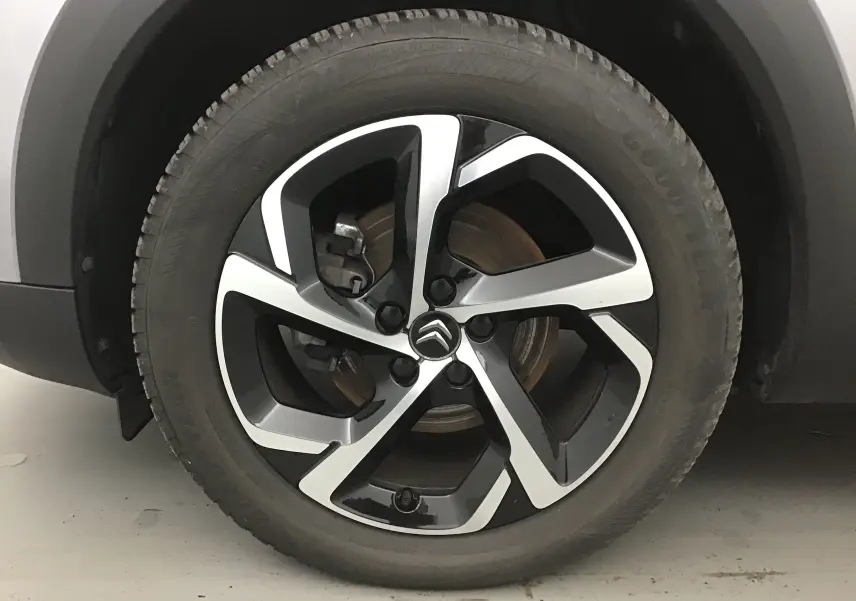 Gros plan sur la roue avant droite du Citroën C5 Aircross gris Artense, jante alliage bicolore au design moderne.