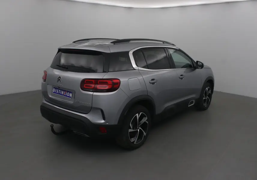 Citroën C5 Aircross gris Artense vu en 3/4 arrière droit, avec jantes noires et toit noir contrasté.