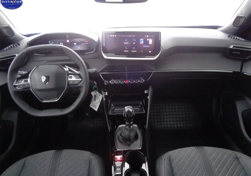 Vue intérieure frontale du tableau de bord et volant noir du Peugeot 2008 2023 avec boîte manuelle et écran tactile central.