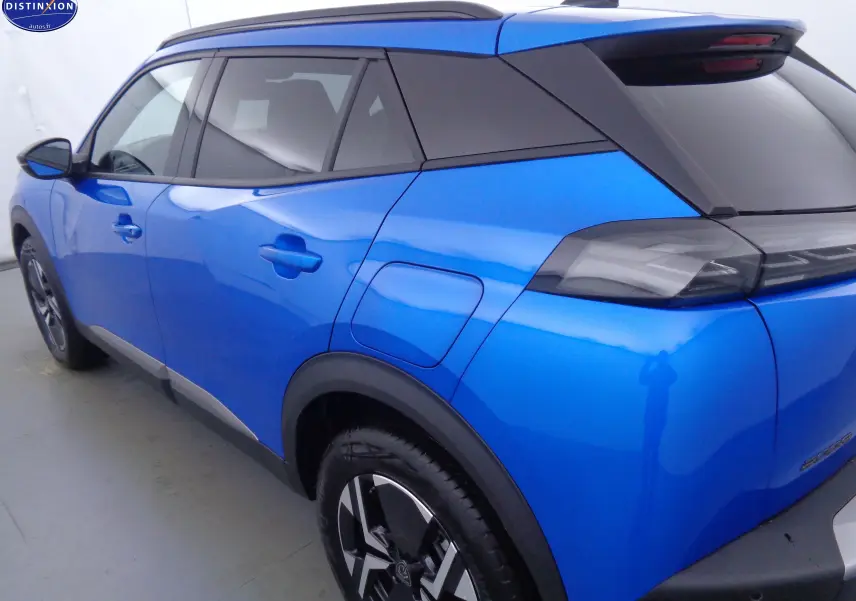 Vue 3/4 arrière droite du Peugeot 2008 bleu Vertigo Metal avec toit noir et jantes bi-ton noires.