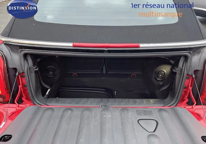 Coffre ouvert d'une MINI Cabriolet F57 rouge chili vue arrière, montrant l'espace de rangement intérieur.