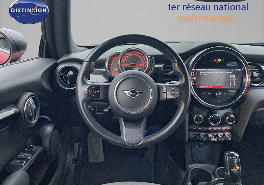 Vue intérieure centrée sur le volant et le tableau de bord numérique de la MINI Cabriolet rouge Chili 2023.