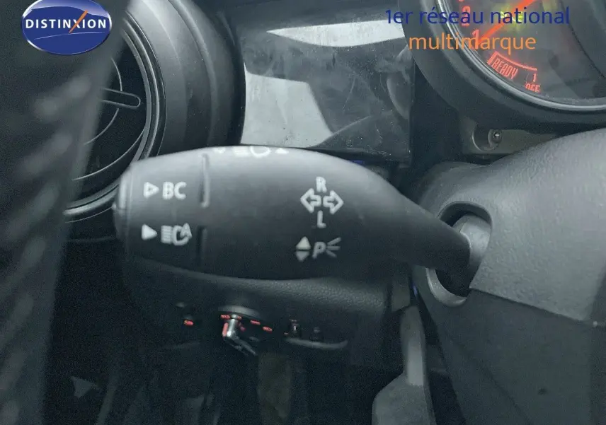 Gros plan sur la commande de clignotant à gauche du volant dans l'habitacle d'une MINI Cabriolet rouge Chili 2023.