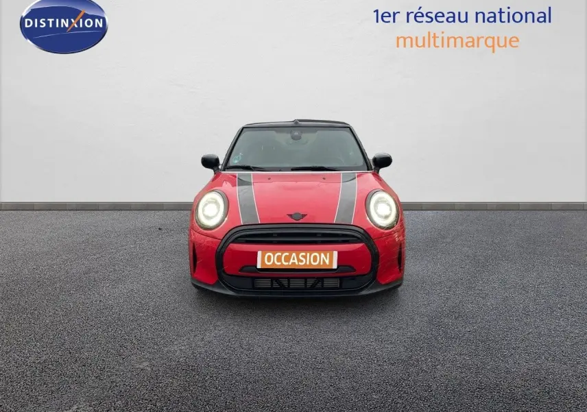 Vue frontale d'une MINI Cabriolet F57 rouge chili avec bandes noires et phares allumés sur fond neutre.