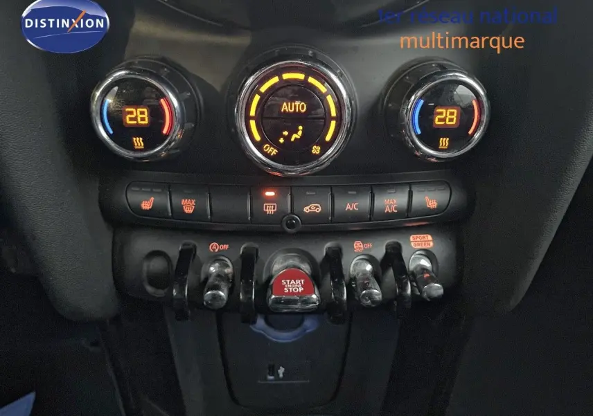 Gros plan sur la console centrale du MINI Cabriolet rouge Chili 2023, montrant les commandes de climatisation et le bouton start/stop.