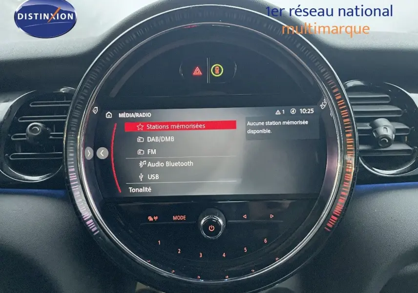 Tableau de bord de MINI Cabriolet F57 rouge chili, vue centrée sur l’écran multimédia circulaire avec options radio affichées.