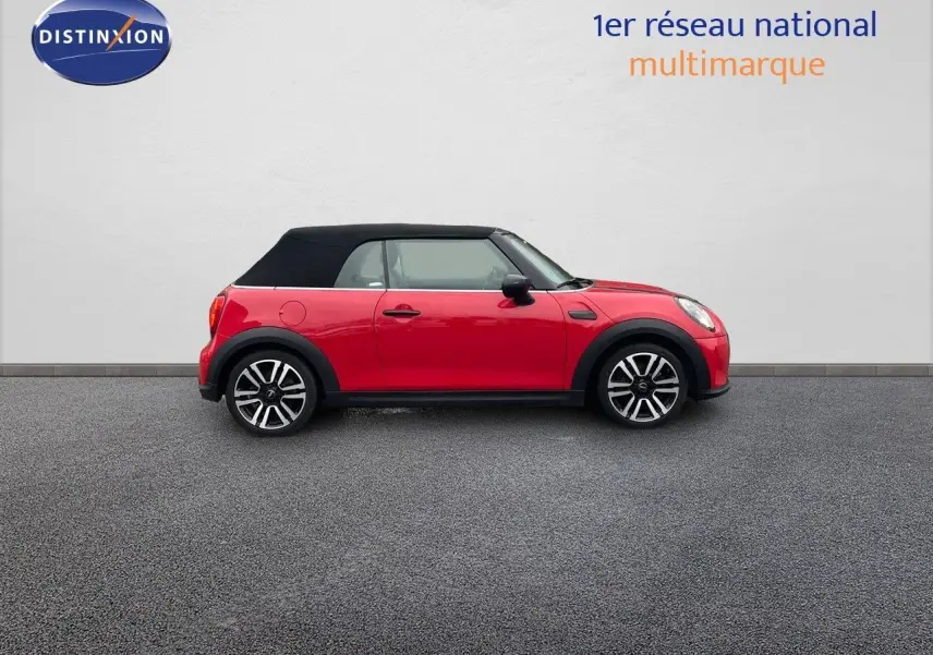 Profil gauche d'une MINI Cabriolet F57 rouge chili avec toit noir fermé et jantes bi-ton.