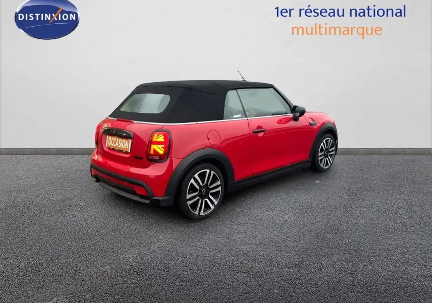 Vue 3/4 arrière droite d'une MINI Cabriolet F57 rouge chili avec toit noir et feux arrière à motif Union Jack.