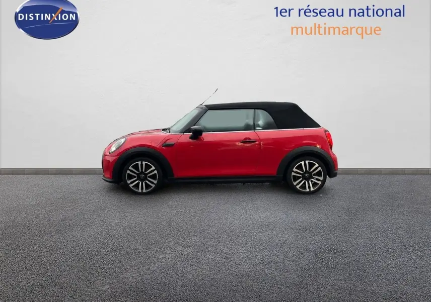 Profil droit d'une MINI Cabriolet F57 rouge chili avec toit noir relevé, roues alliage 17 pouces bi-ton visibles.