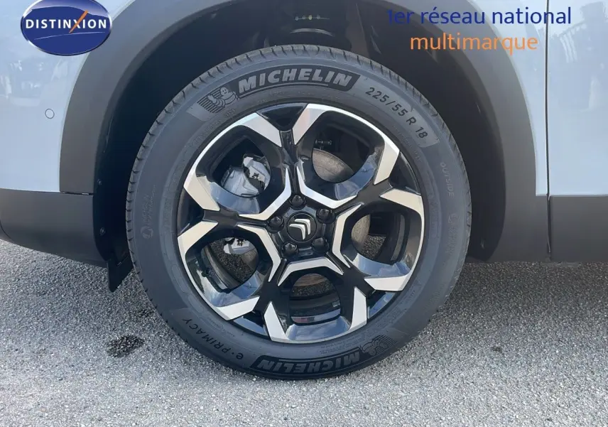 Gros plan sur la roue avant droite du Citroën C5 Aircross blanc Okenite métal avec jante bi-ton noire et argent.