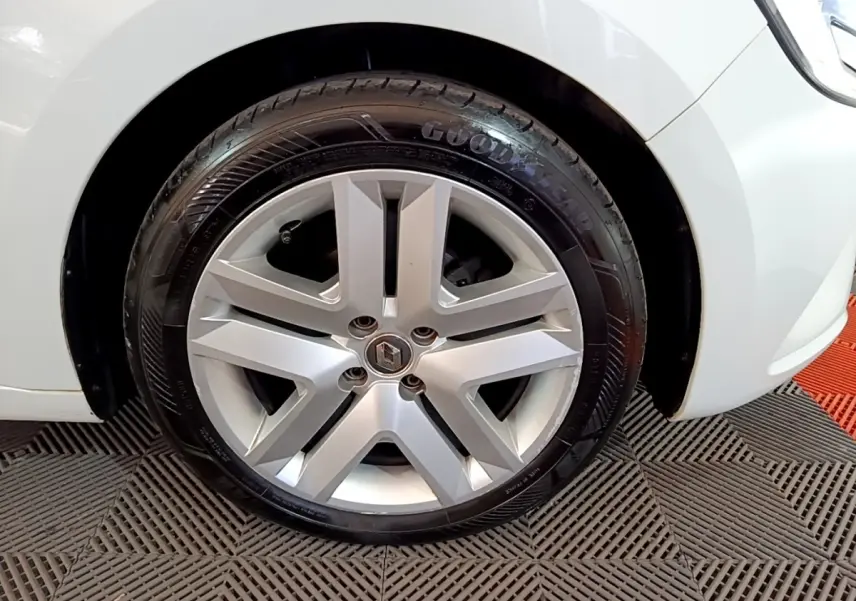 Gros plan sur la roue avant gauche d'une Renault Clio Business blanche, avec jante alliage et pneu Goodyear visible.