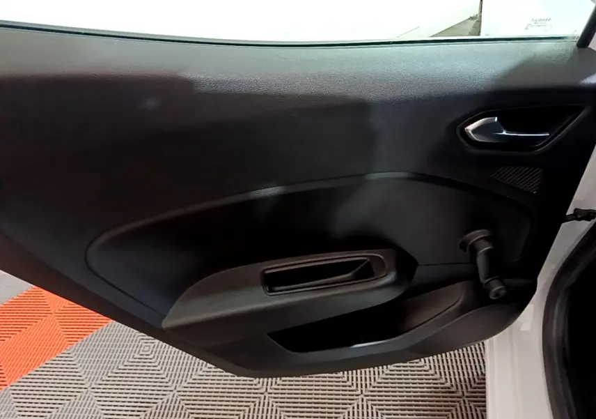 Vue intérieure de la porte arrière droite noire d’une Renault Clio Business blanche avec poignée manuelle de vitre.