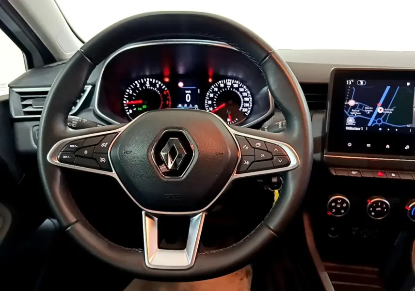 Vue intérieure centrée sur le volant noir Renault Clio 2021 avec tableau de bord et écran tactile de navigation.