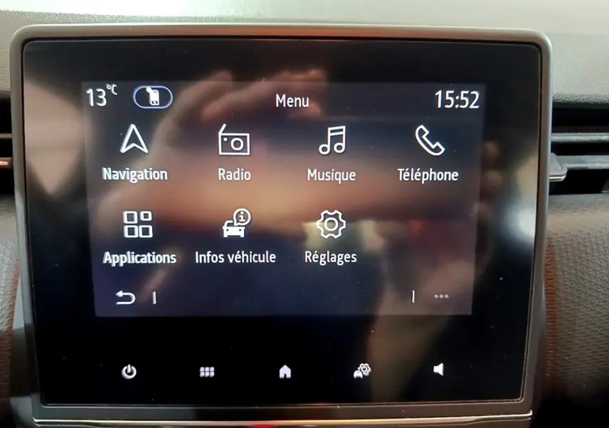 Écran tactile central de la Renault Clio Business blanc, affichant le menu principal avec navigation et radio.