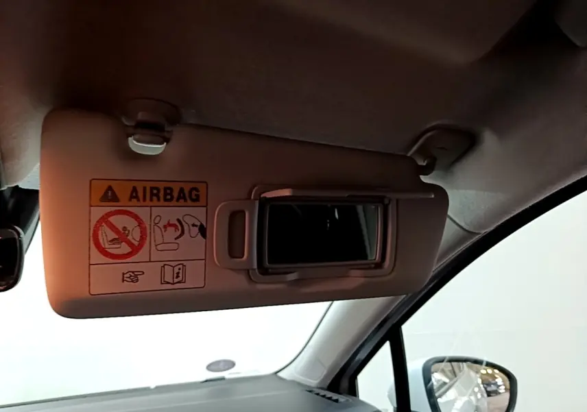 Détail du pare-soleil côté conducteur de la Renault Clio Business blanche 2021 avec miroir et avertissement airbag visible.