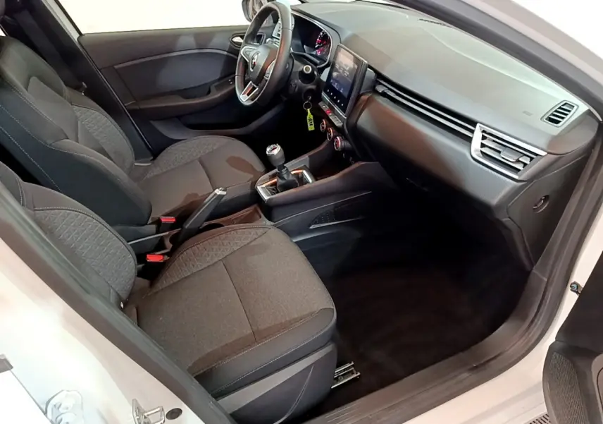 Intérieur vue côté conducteur d’une Renault Clio Business blanche, sièges tissu gris, tableau de bord avec écran tactile vertical.