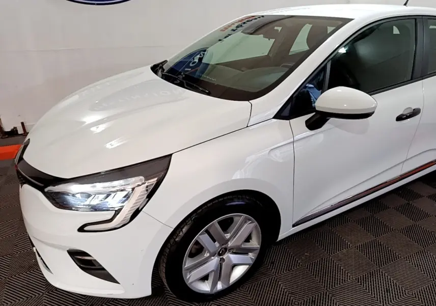 Renault Clio Business blanc vue 3/4 avant droit, avec phares LED allumés et jantes alliage visibles.