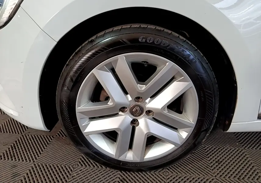 Gros plan sur la roue avant droite d’une Renault Clio blanche avec jante alliage et pneu Goodyear.