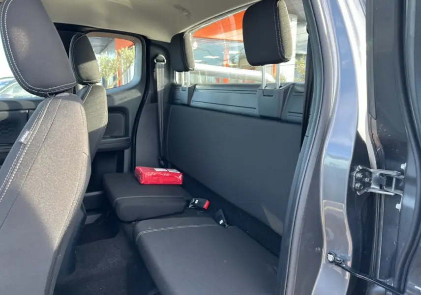 Vue intérieure côté droit du Ford Ranger Supercab 2026 noir shadow, montrant la banquette arrière et un accoudoir central relevé.