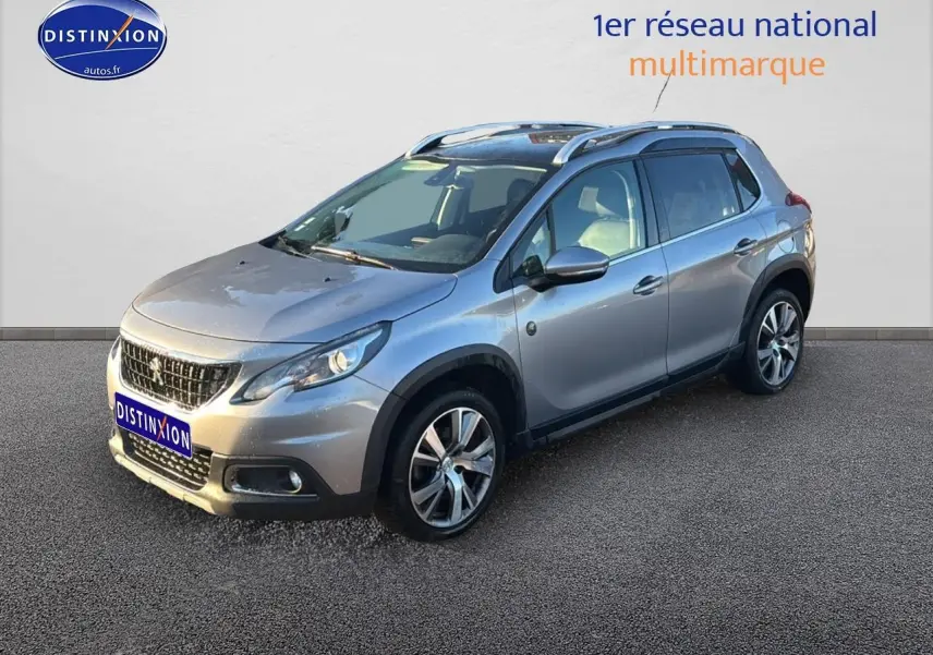 Peugeot 2008 gris clair vue 3/4 avant droit avec barres de toit et jantes alu diamantées.