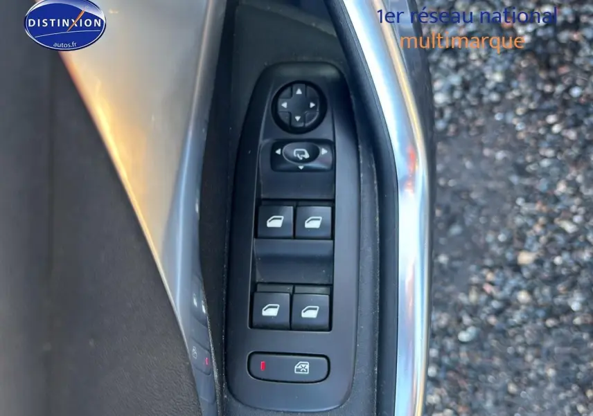 Gros plan sur les commandes des vitres électriques côté conducteur d’une Peugeot 2008 gris clair.