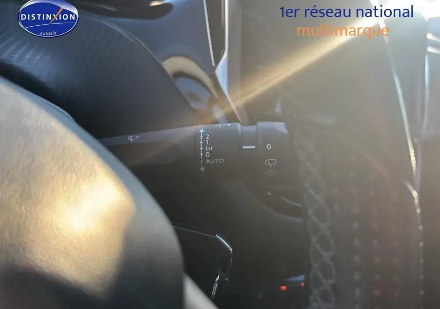 Détail du commodo d’essuie-glace côté gauche dans l’habitacle sombre d’une Peugeot 2008 gris clair.