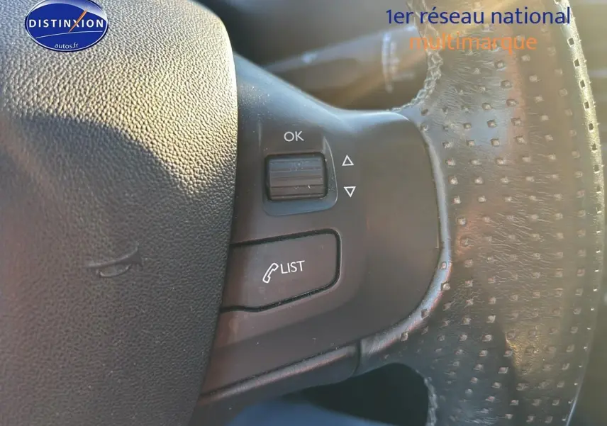 Gros plan sur le volant cuir perforé de la Peugeot 2008 2019 avec commandes multifonctions visibles.