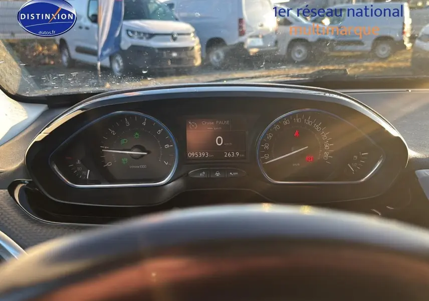 Vue intérieure du tableau de bord du Peugeot 2008 gris clair, affichant les compteurs et l'écran multifonction au centre.