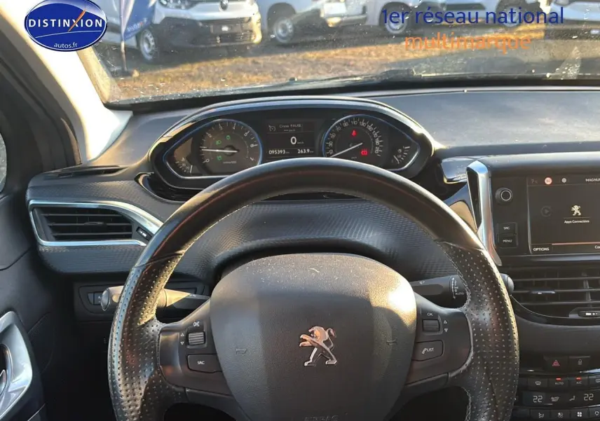 Vue intérieure centrée sur le volant cuir multifonction et le tableau de bord du Peugeot 2008 gris clair de 2019.