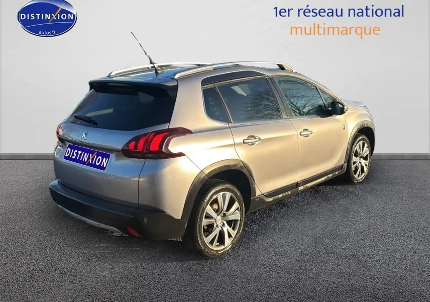 Peugeot 2008 gris clair vue 3/4 arrière droit avec barres de toit et vitres teintées sur fond neutre.