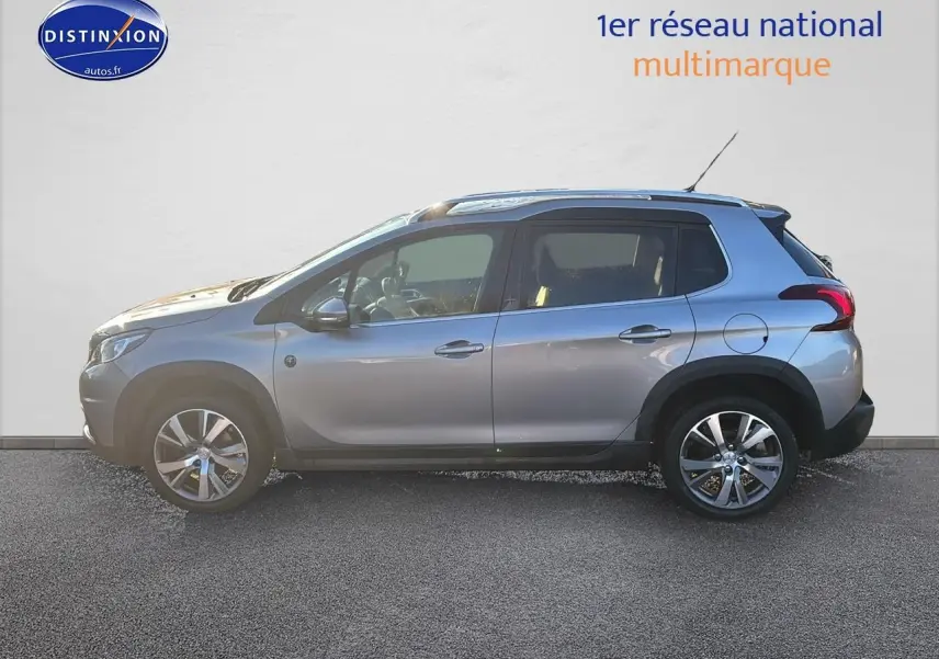 Profil droit d'un Peugeot 2008 gris clair de 2019 avec jantes alu et barres de toit visibles.