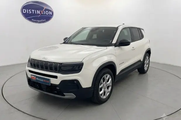 Jeep Avenger blanc en 3/4 avant droit, avec calandre noire distinctive et jantes alliage 17 pouces visibles.