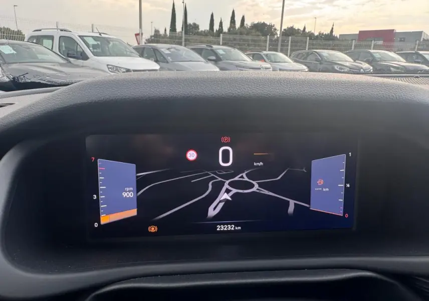 Vue intérieure du tableau de bord numérique du Jeep Avenger blanc, affichant la vitesse à 0 km/h et un compteur de 23 232 km.