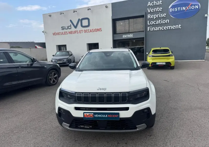 Vue de face d'un Jeep Avenger blanc 2025 avec calandre noire et plaques d'immatriculation du concessionnaire.