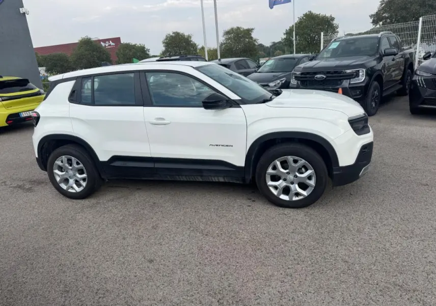 Jeep Avenger blanc en vue de profil côté gauche, avec jantes alliage et bas de caisse noir contrastant.
