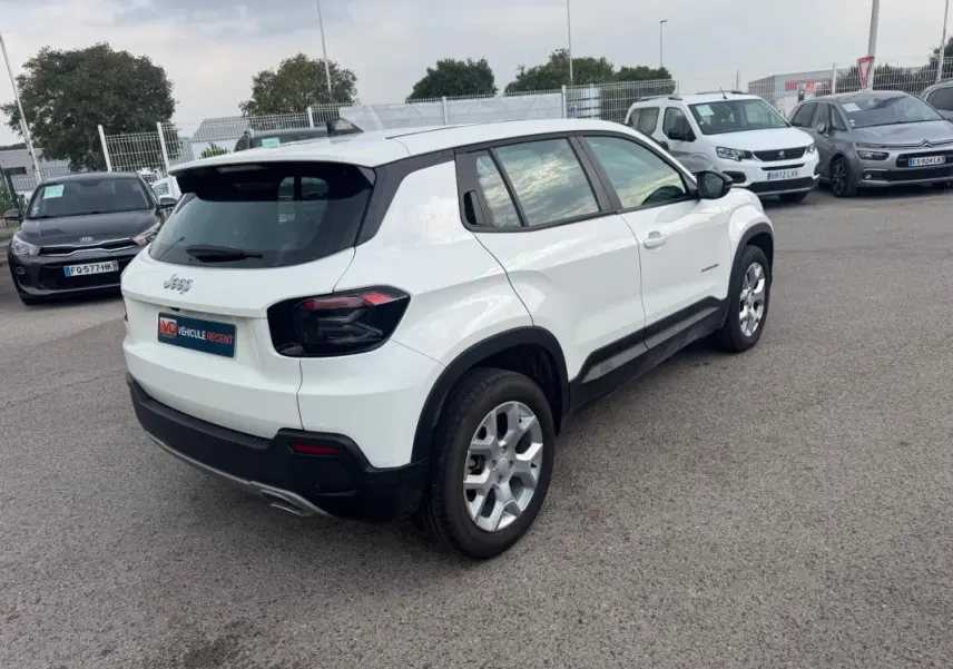 Jeep Avenger blanc en 3/4 arrière droit, avec jantes alliage 17 pouces et feux arrière teintés noirs.
