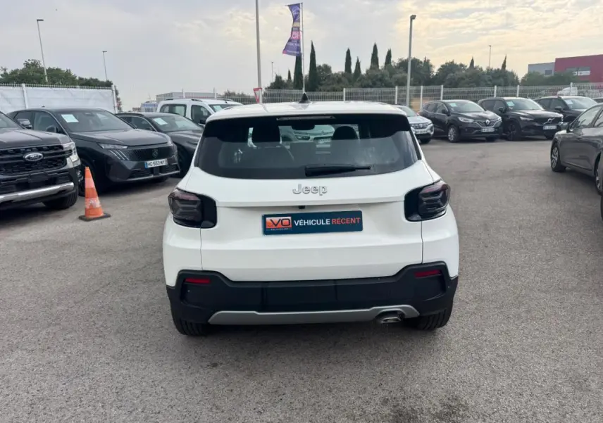 Vue arrière d'un Jeep Avenger blanc 2025 avec feux arrière fumés et plaque V.O. Véhicule Récent visible.
