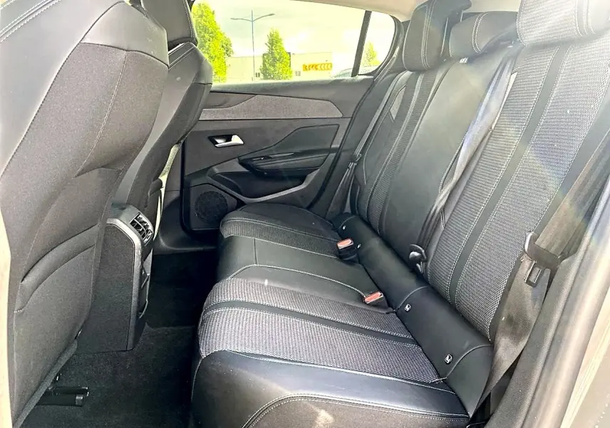 Vue latérale droite de la banquette arrière noire de la Peugeot 308 2025, avec appuie-têtes et ceintures visibles.