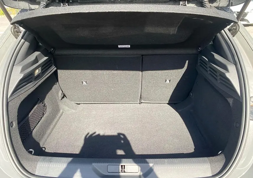Coffre ouvert vu de l'arrière d'une Peugeot 308 gris, montrant un espace de chargement propre et bien fini.